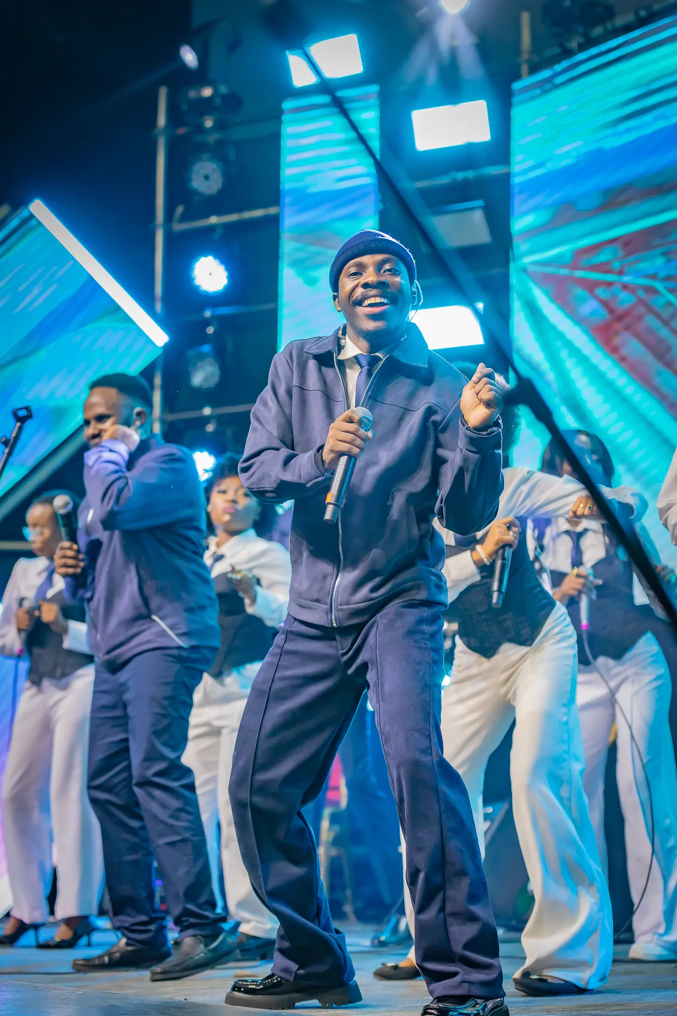 Paddy Daniel leading worship with a choir behind him