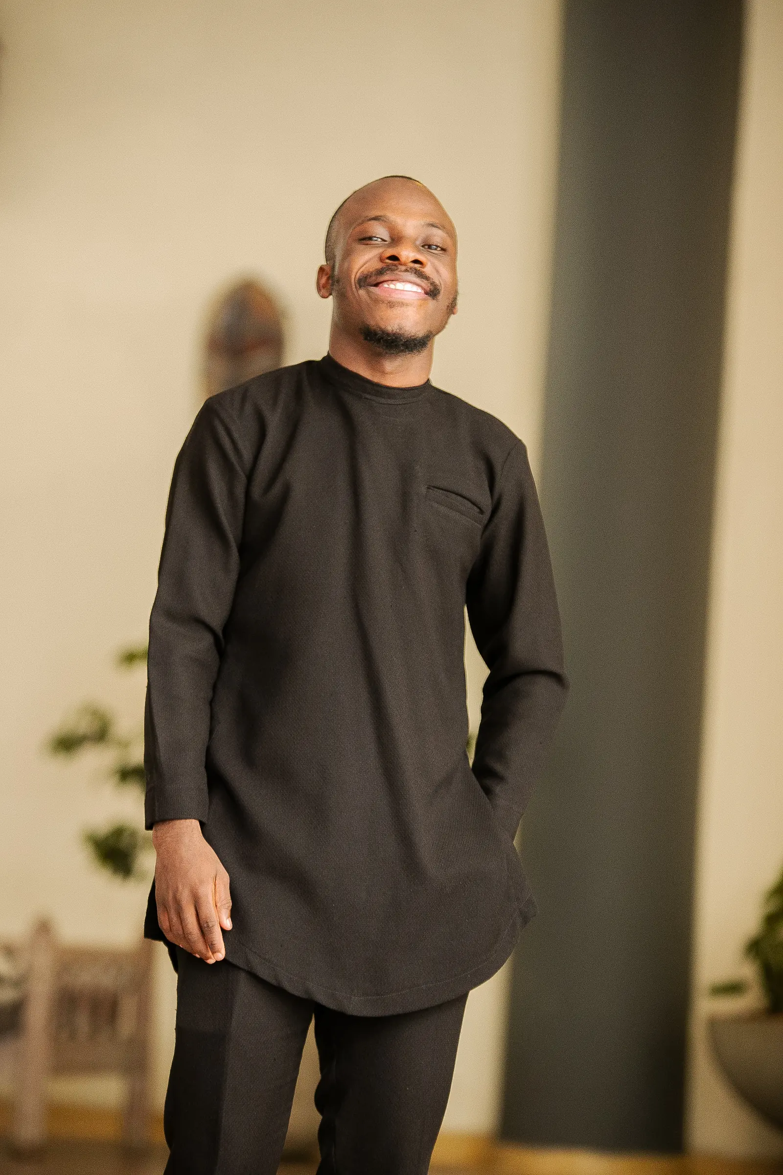 Paddy Daniel in a black kaftan, warm studio portrait