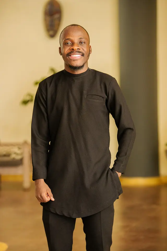 Paddy Daniel in a black kaftan, full-length portrait