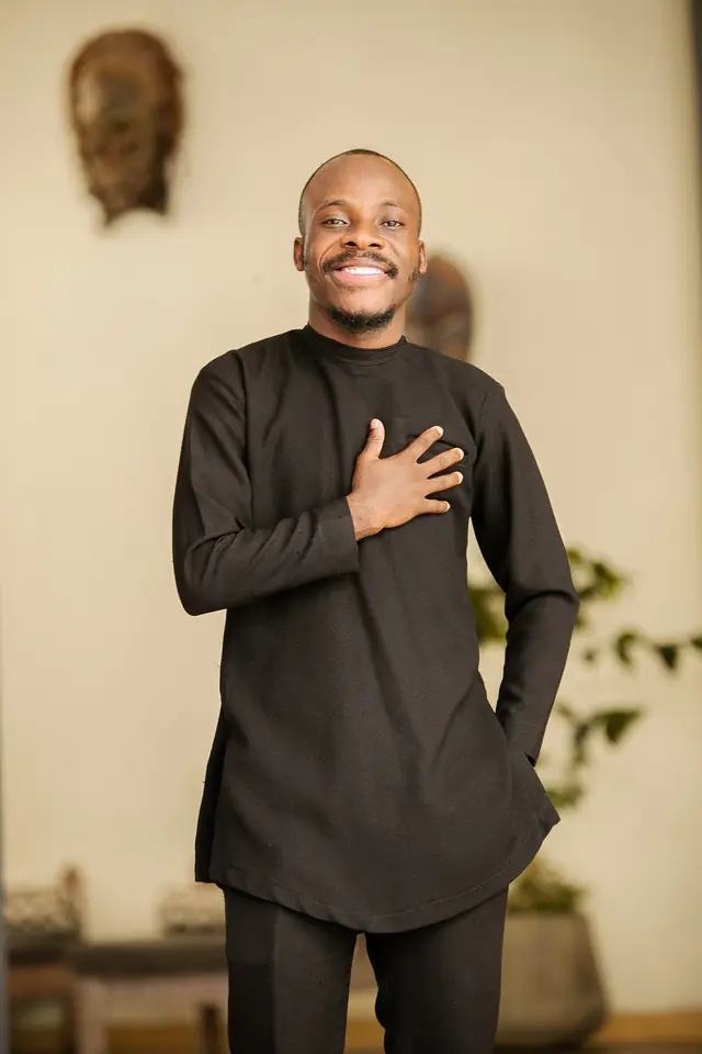 Paddy Daniel with his hand on his heart in a black kaftan