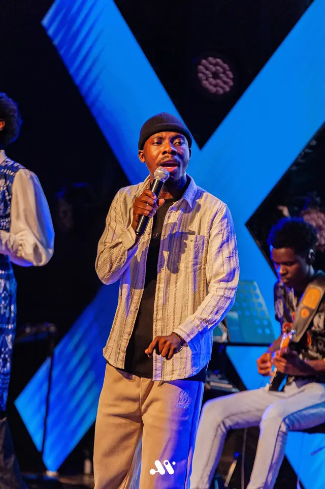 Paddy Daniel performing with band members on a blue stage