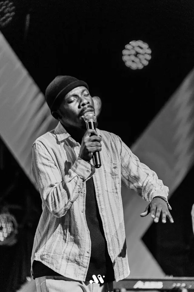 Paddy Daniel singing with his hand raised, black and white